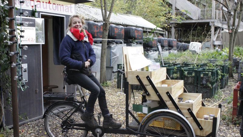 Eine Frau sitzt auf dem Saatgut Rad und lächelt in die Kamera.